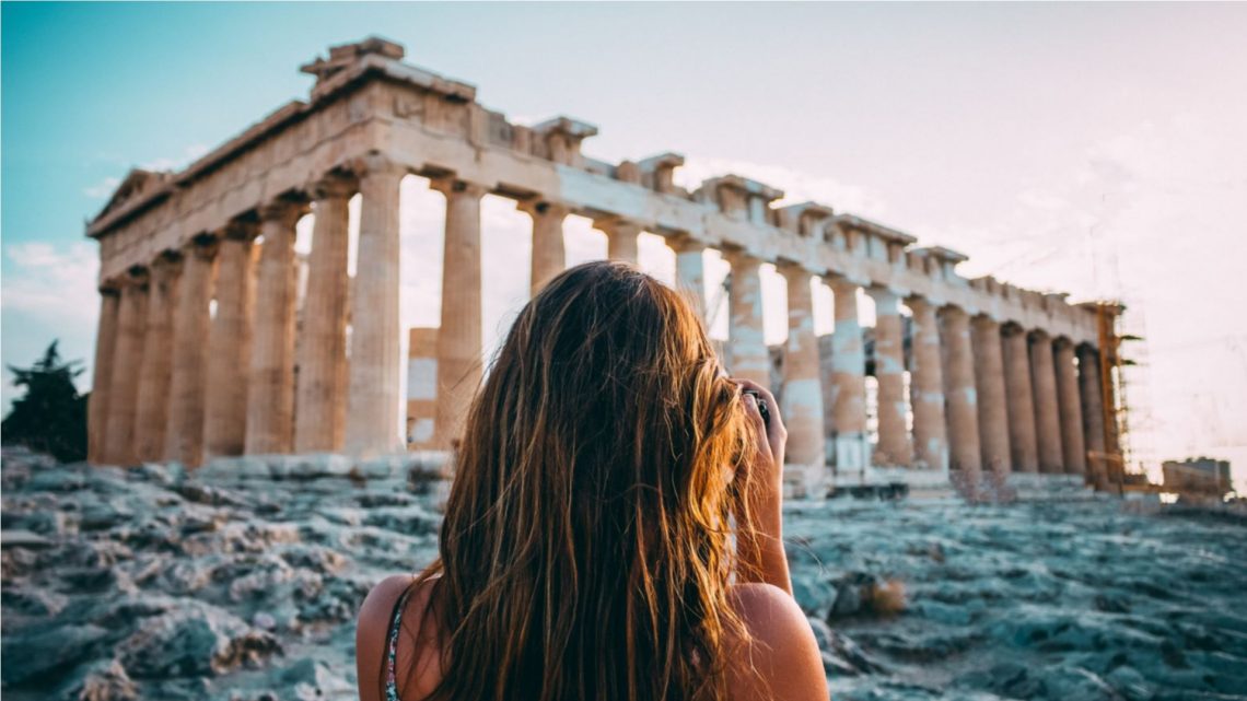 kobieta stojąca naprzeciwko Partenonu w Atenach. Grecja poza sezonem